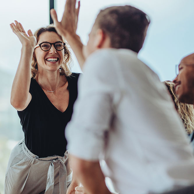 Willkommen bei cirQum Eine Frau und ein Mann klatschen sich mit den Händen ab.
